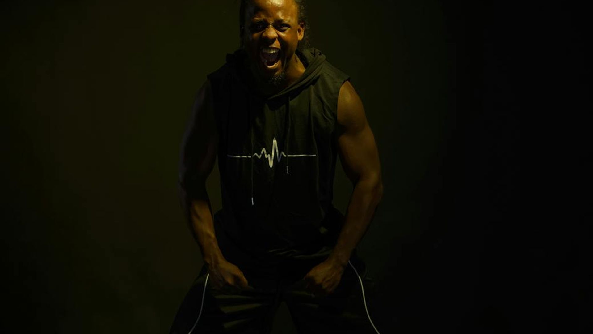 Active man doing dynamic cardio movements in dark studio.