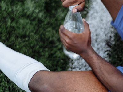 Athletic shoes and a bottle of water on the floor.